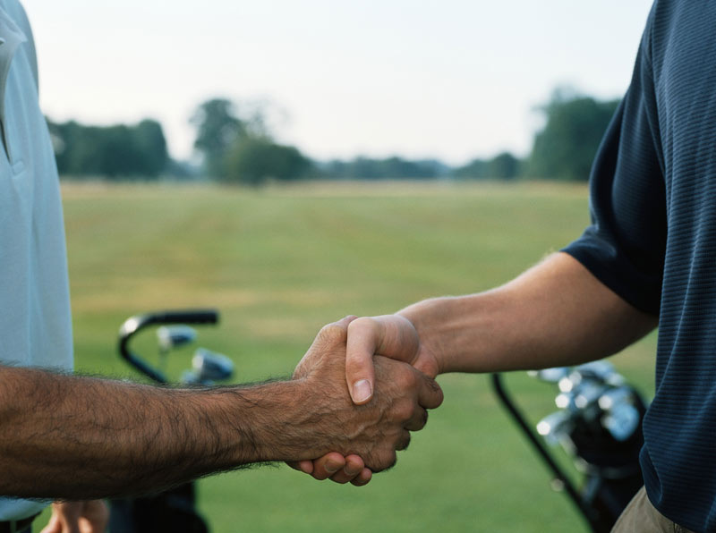 Men shaking hands on golf course