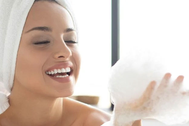 A woman washing her face with foam