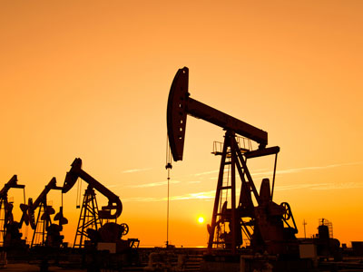 Silhouette of an oil well at sunset