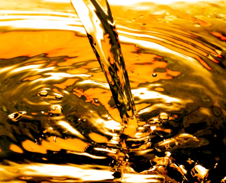 Amber colored oil pouring into a container